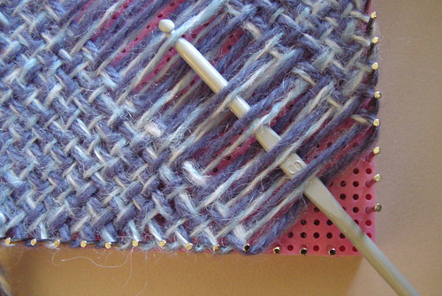 Weaving a continuous weave, bias square, showing the removal of the corner pins.