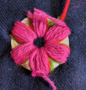 A third layer of pink wool is stitched over the first two.