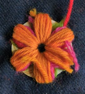 A final layer of orange wool is stitched over the first three.