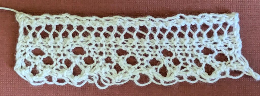 A narrow knitted lace edging with small diamond design made of four eyelets.