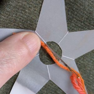 Beginning to stitch over the template with wool yarn.