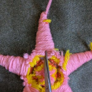 Beginning to cut the yarn up the centre of the first arm of the star.