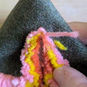 Close up showing the tiny stitches at the tip of the arm are uncut.