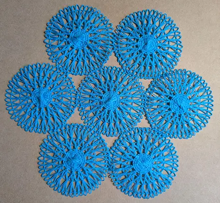 7 small teneriffe lace motifs joined into a doily with 6motifs sewn around a centre motif.